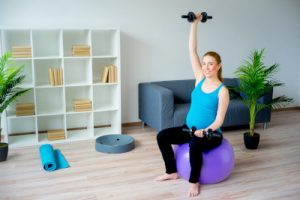 Pregnant woman sitting on a gym ball.