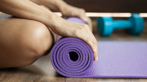 Woman rolling up exercise mat